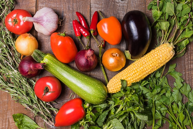 Layout with different vegetables on old wooden table.