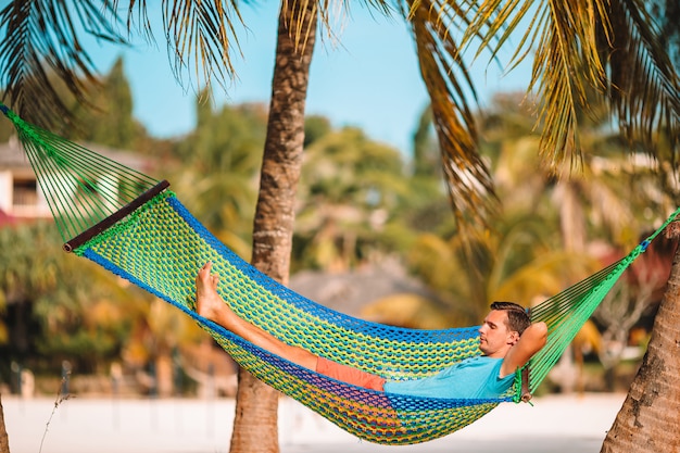 Lazy time. Man in hat in a hammock on a summer day