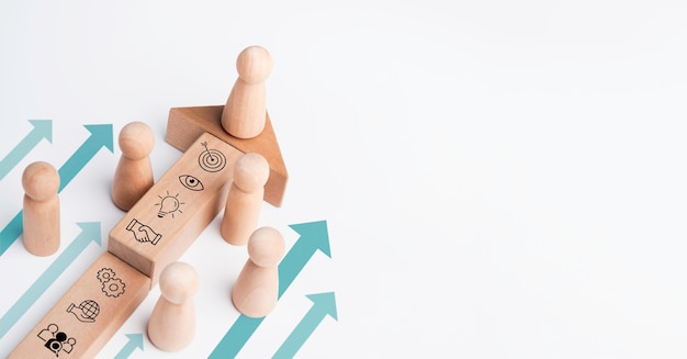 The leader, wooden figure leading the team with business icon\
on wood block with heading arrows on white background with copy\
space. business strategy with growth success process, leadership\
concept.