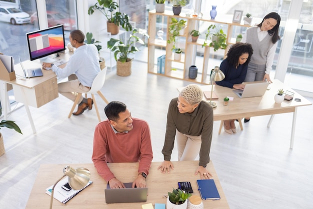 Leadership black woman or manager coaching a worker in startup or group project in a digital agency Team work laptop or employee helping talking or speaking of our vision or branding direction