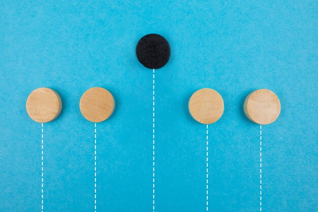 Photo leadership concept black wooden block on a blue background another not like everyone else