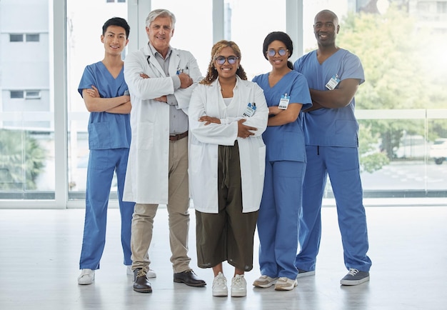 Leadership portrait doctors and nurses with arms crossed standing together in hospital Face teamwork and confident medical professionals group or happy surgeons with collaboration for healthcare