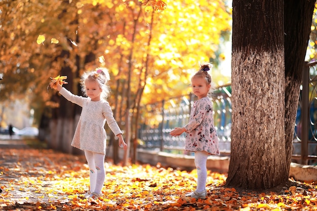 Leaf fall in the park. Children for a walk in the autumn park. Family. Fall. Happiness.