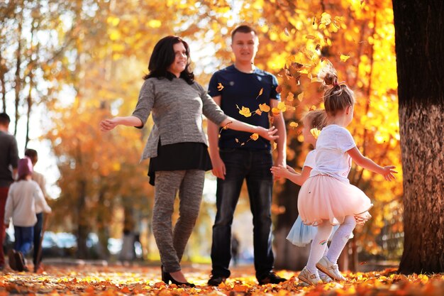 公園に葉が落ちる。秋の公園を散歩する子供たち。家族。秋。幸せ。
