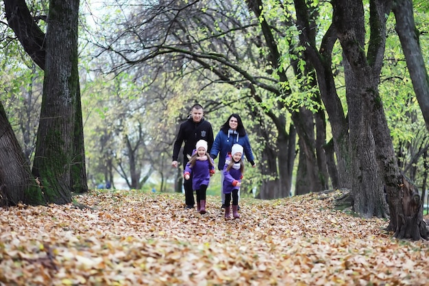 Leaf fall in the park. Children for a walk in the autumn park. Family. Fall. Happiness.