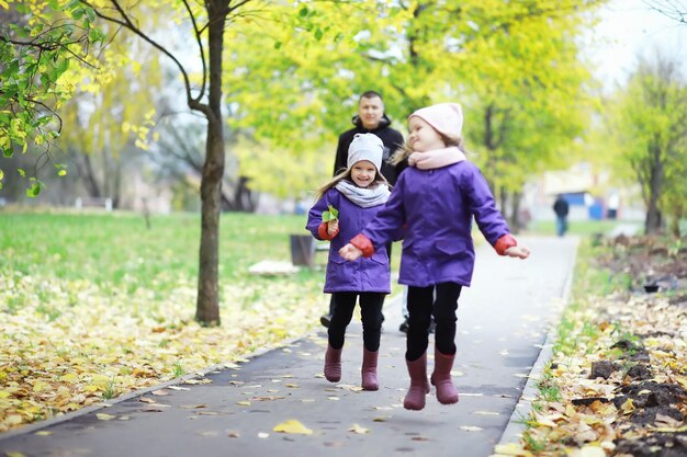 Caduta delle foglie nel parco. bambini per una passeggiata nel parco autunnale. famiglia. autunno. felicità.