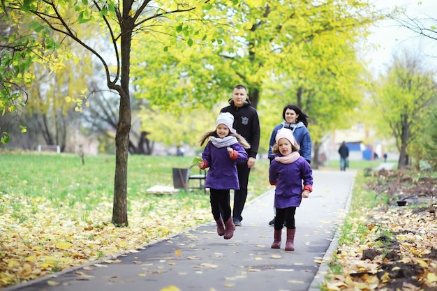 Caduta delle foglie nel parco. bambini per una passeggiata nel parco autunnale. famiglia. autunno. felicità.