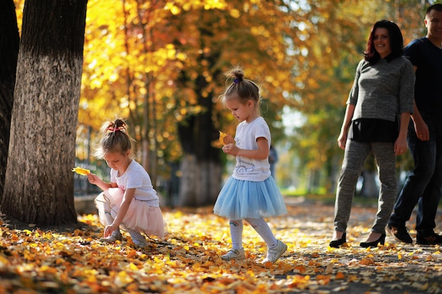 Leaf fall in the park. Children for a walk in the autumn park. Family. Fall. Happiness.