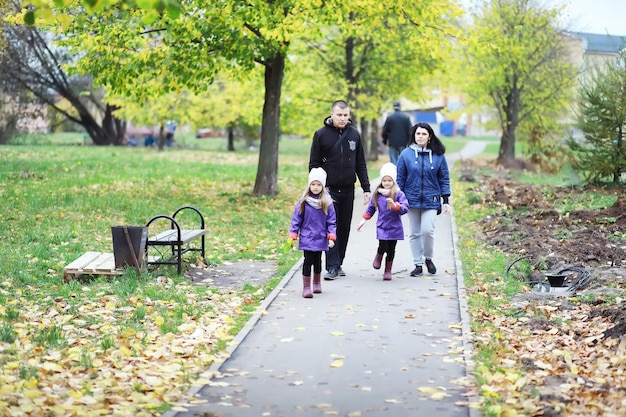 Leaf fall in the park Children for a walk in the autumn park Family Fall Happiness