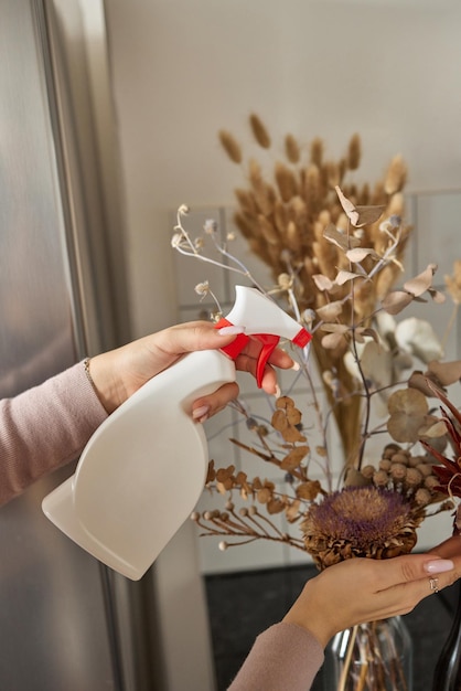 水滴で湿らせた観葉植物のスパティフィラムの葉を手に水分を好む熱帯屋内f