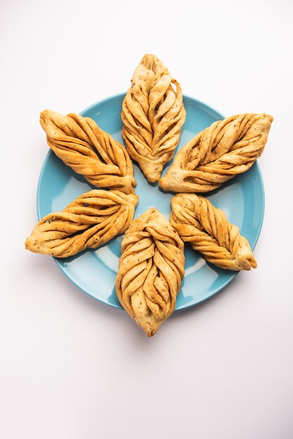 Foto a forma di foglia o laccha mathri o mathiya è uno spuntino per l'ora del tè del rajasthan. è un biscotto fritto a scaglie della regione nord-occidentale dell'india