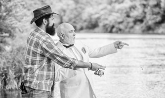 Photo learn to fish fish with companion who can offer help in emergency fishing skills men friends relaxing nature background personal instructor bearded man and elegant businessman fish together