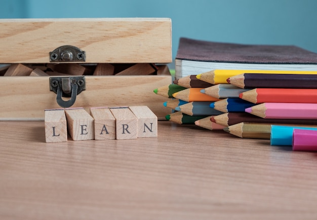 LEARN text and school supplies on wooden background