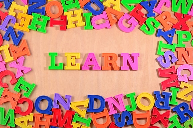 Learn written by plastic colorful letters on a wooden background