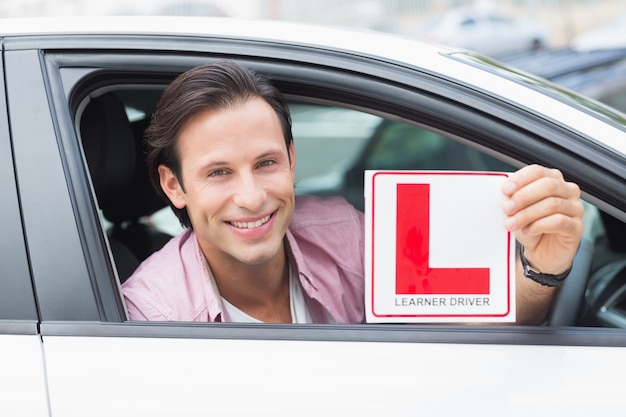 Photo learner driver smiling and holding l plate