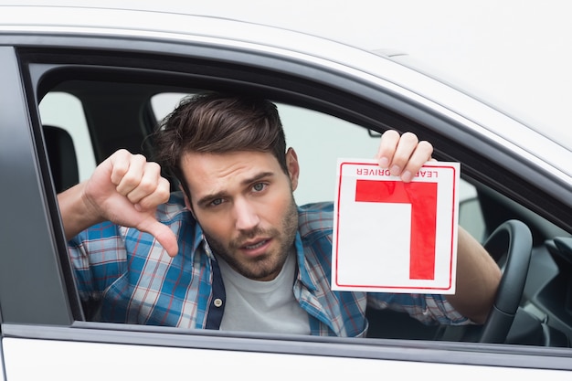 Learner driver smiling and holding l plate