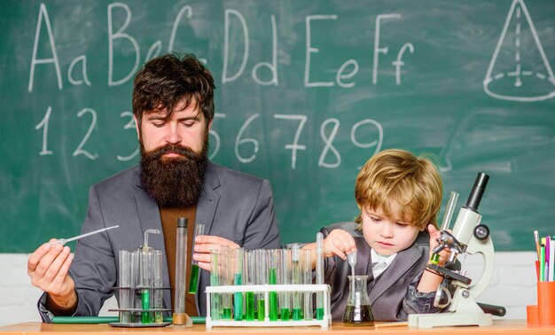 Learning chemistry in school lab Back to school father and son at school Scientist research and experiments teacher man with little boy Biology Science lab Chemistry is dirty part of physics