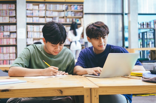 학습, 교육 및 학교 개념. 시험 또는 시험을 위해 공부하는 젊은 여자와 남자. 친구와 함께 튜터 책. 어린 학생들의 캠퍼스는 친구가 따라 잡고 배우는 데 도움이됩니다.