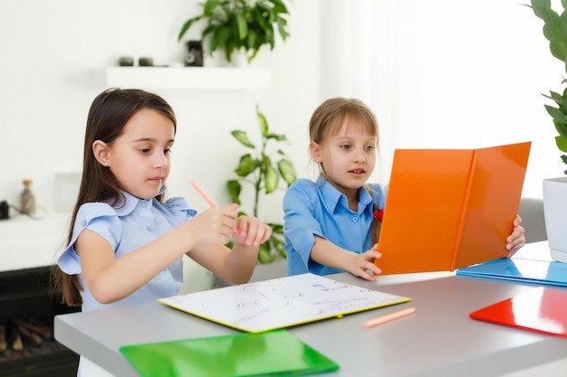 家から学ぶ、ホームスクールの子供の概念。小さな子供たちは、ラップトップを使って自宅からオンライン学習を学びます。検疫と社会距離拡大の概念。