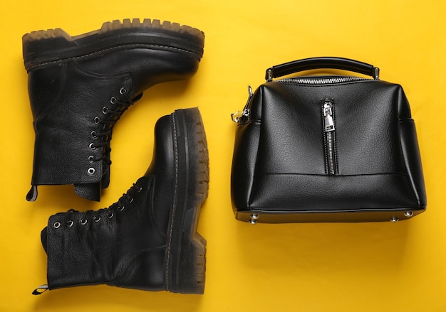 Leather bag and boots on yellow background Top view