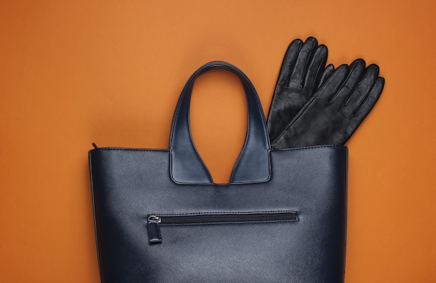 Leather bag and gloves on brown paper