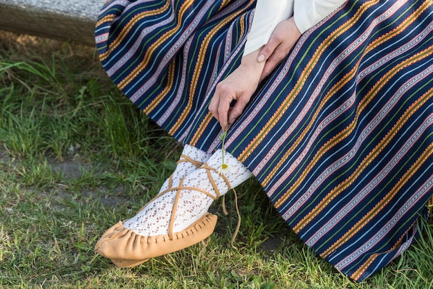 Foto scarpe da rafia in pelle di una donna lettone in abiti tradizionali preparazione del festival ligo riga lettonia