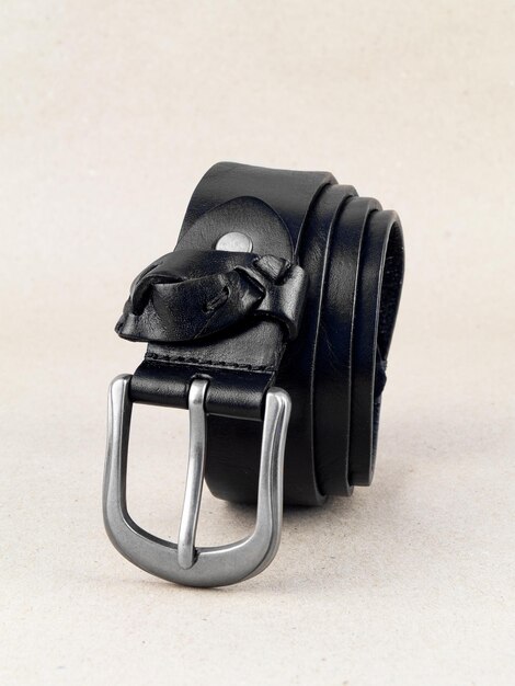 A leather belt with a clasp lies neatly on the table