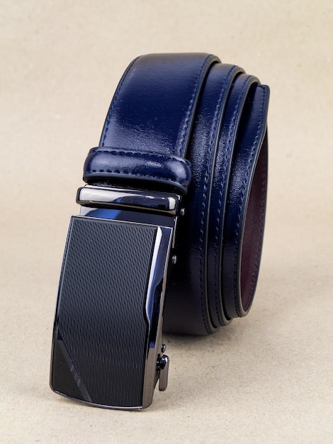 A leather belt with a clasp lies neatly on the table