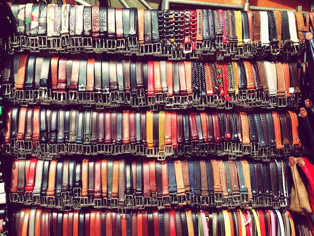 Photo leather belts arranged on shelf in market