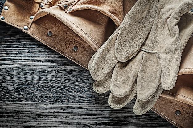 Leather construction belt protective gloves on black board