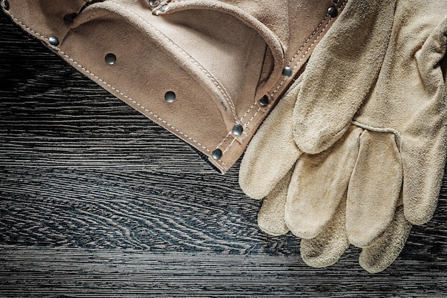 Leather construction belt safety gloves on black board