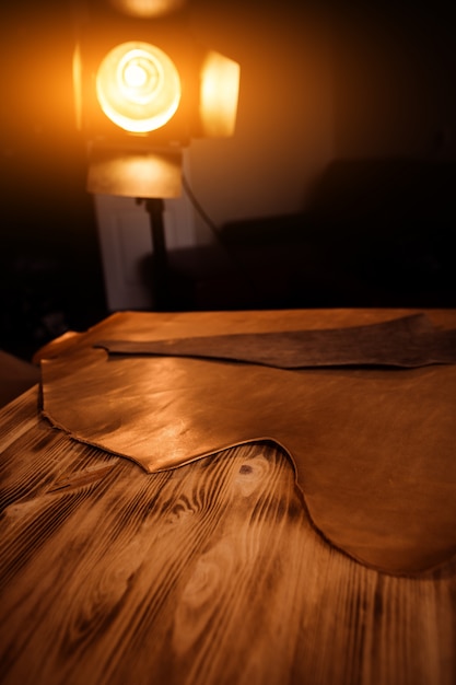 Leather craft on wooden background. tanner's workshop.