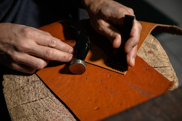 Photo leather craftsman works at the tanner shop