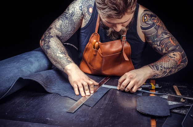 Leather Currier cutting out leather shapes for a new product.