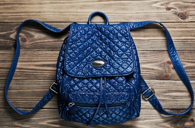 Leather fashion backpack on wooden surface. 