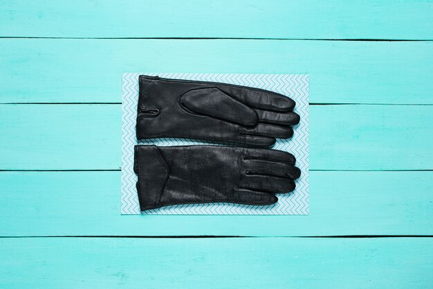 Photo leather gloves on blue wooden surface.