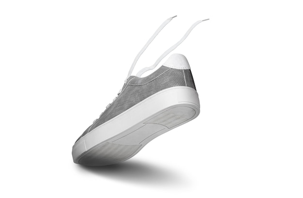Foto sneakers da uomo in pelle colore grigio con pizzo bianco e suole in gomma isolate su sfondo bianco