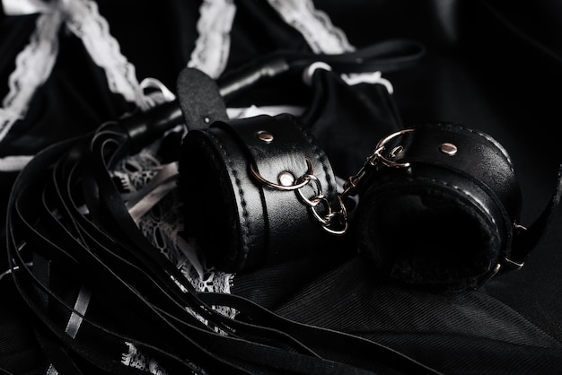 Leather handcuffs and whip for BDSM and maid costume