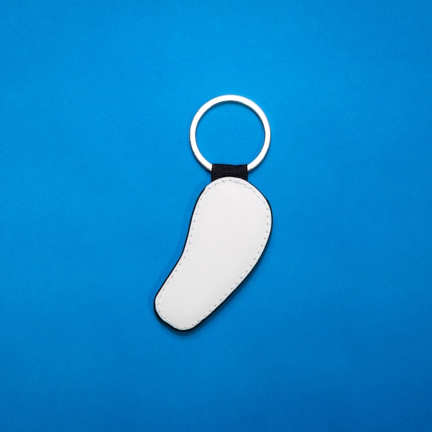 Leather key ring in curve shape on blue paper background