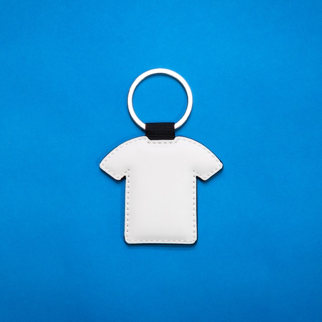 Leather key ring in shirt shape on blue paper background