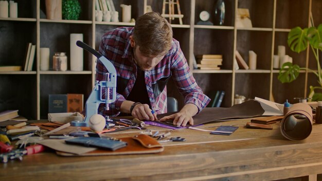 Photo leather manufacturer working at small workshop