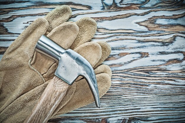 Leather protective gloves claw hammer on wooden board