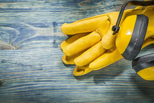 Leather safety gloves earmuffs on wooden board construction concept