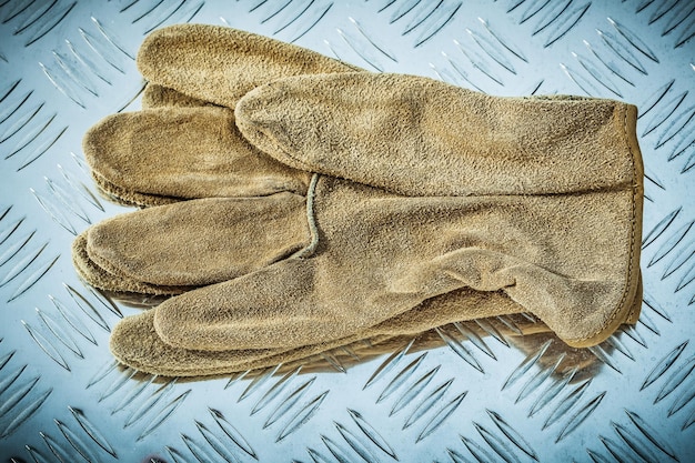 Кожаные защитные перчатки на рифленой металлической текстуре