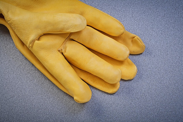 Leather safety gloves on grey background directly above construction concept