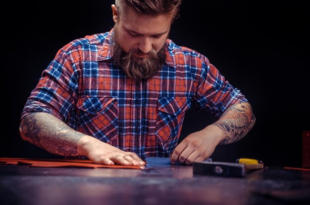 Leather Skinner creating new leatherwork at his workshelf