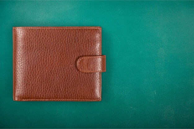 Leather wallet on green background