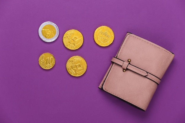 Leather wallet with coins on purple