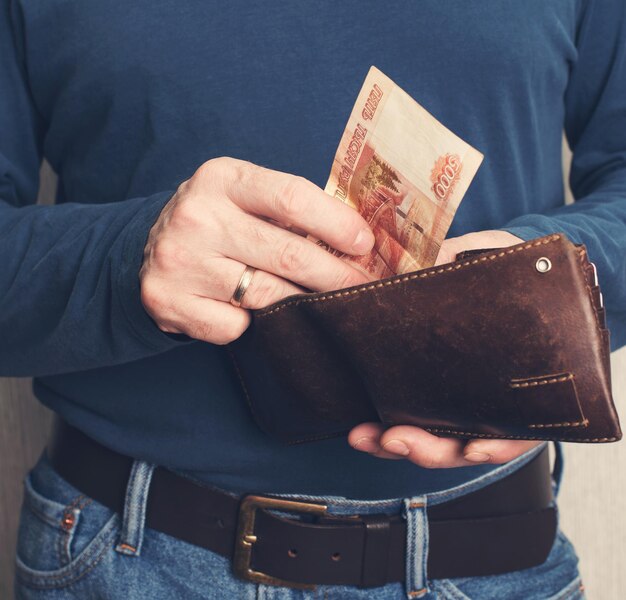 Leather wallet with money in male hands Purse with roubles in male hands