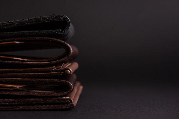 leather wallets on a black background with space for an inscription. Leather craft concept.